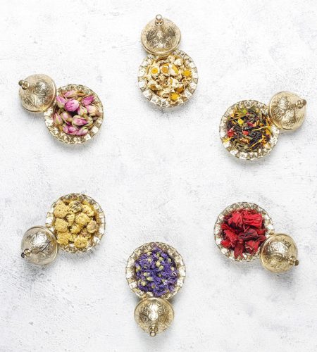 Assortment of dry tea in golden vintage mini plates.Tea types ba